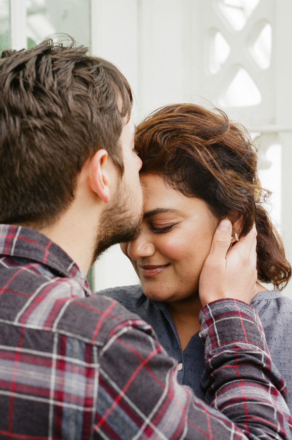 35mm film portrait of beautiful couple, kissing forehead