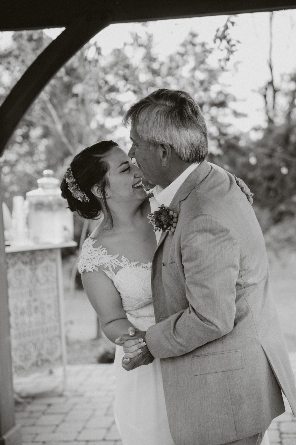 A tender moment between newlyweds sharing an intimate embrace during their outdoor wedding ceremony.
