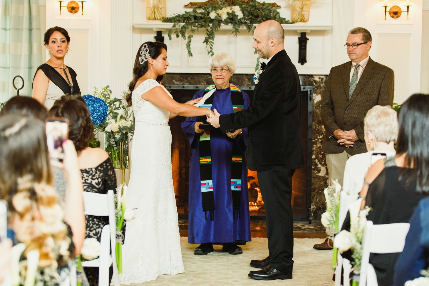Wedding ceremony proceedings take place in an elegant indoor venue with classic decor.