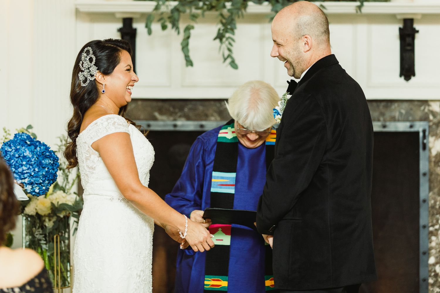 Panoramic shot of a wedding ceremony in a bright white venue with elegant decor.