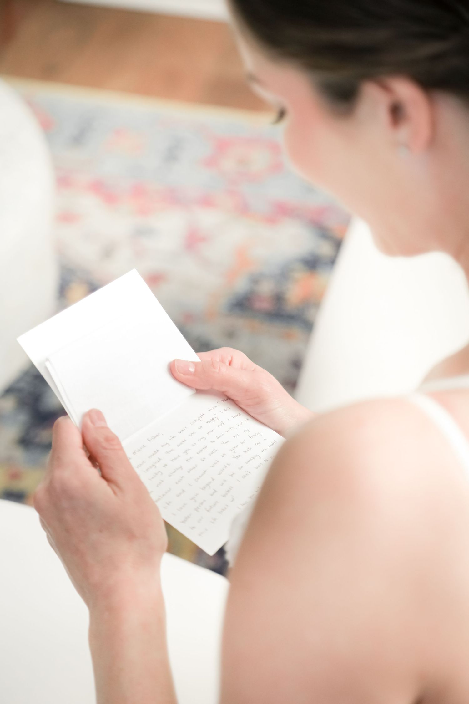 Close-up view of someone reading a handwritten letter or vows on their wedding day.