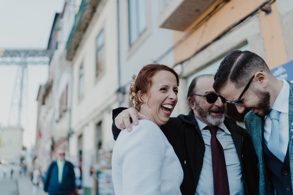 Bride and groom laughing with friends during a Porto wedding