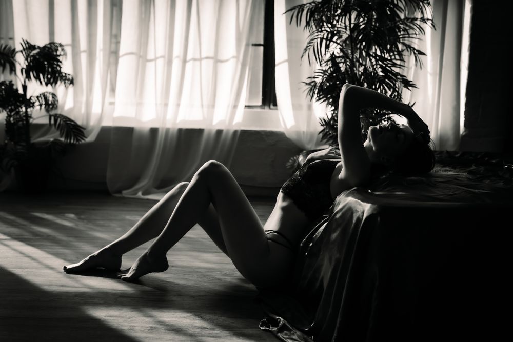 black and white photograph with woman posed on the floor