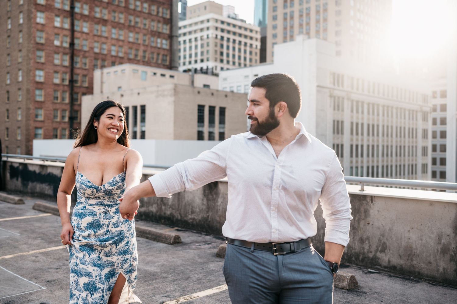 Rooftop engagement photoshoot with urban architecture and city buildings in background.