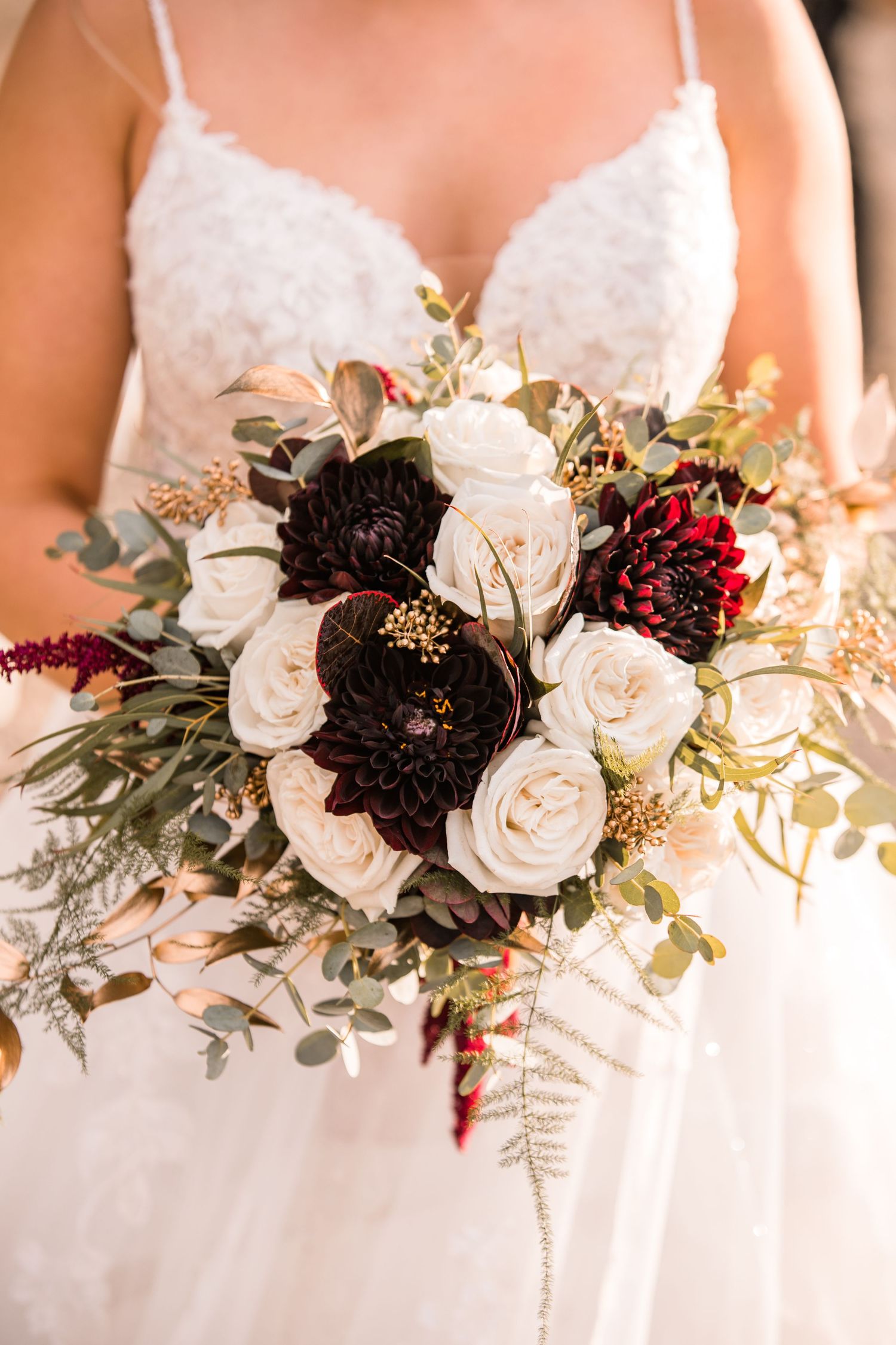 Bride holding bouquet in front of her with white flowers and golden light photo by Pelka Photography Alicante Spain