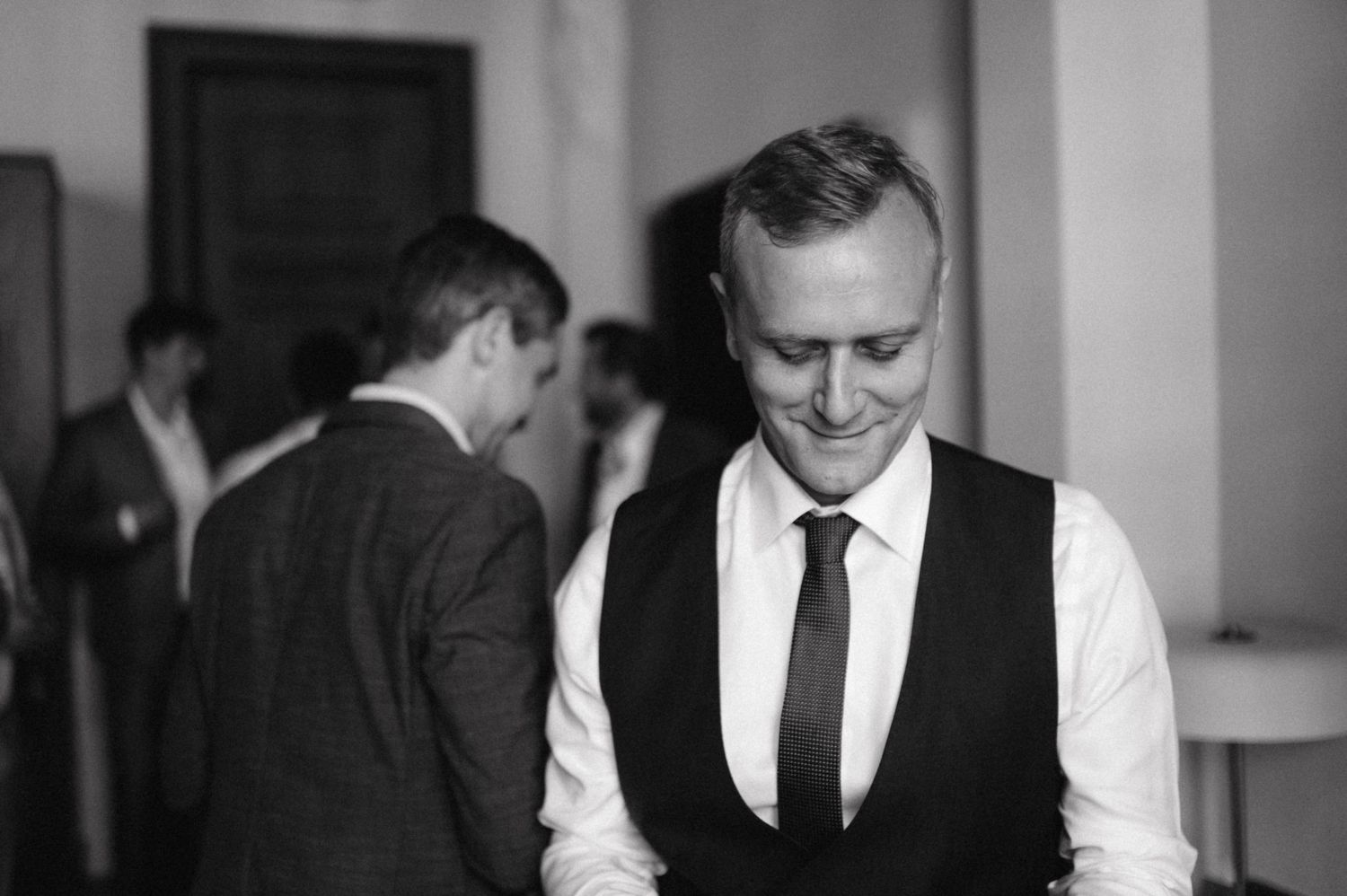 A black and white photo showing men in formal attire having a conversation.