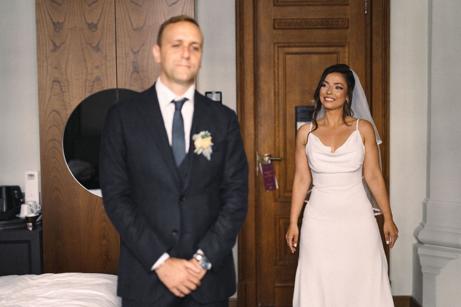 Emotional first look between bride in white dress and groom in dark suit.