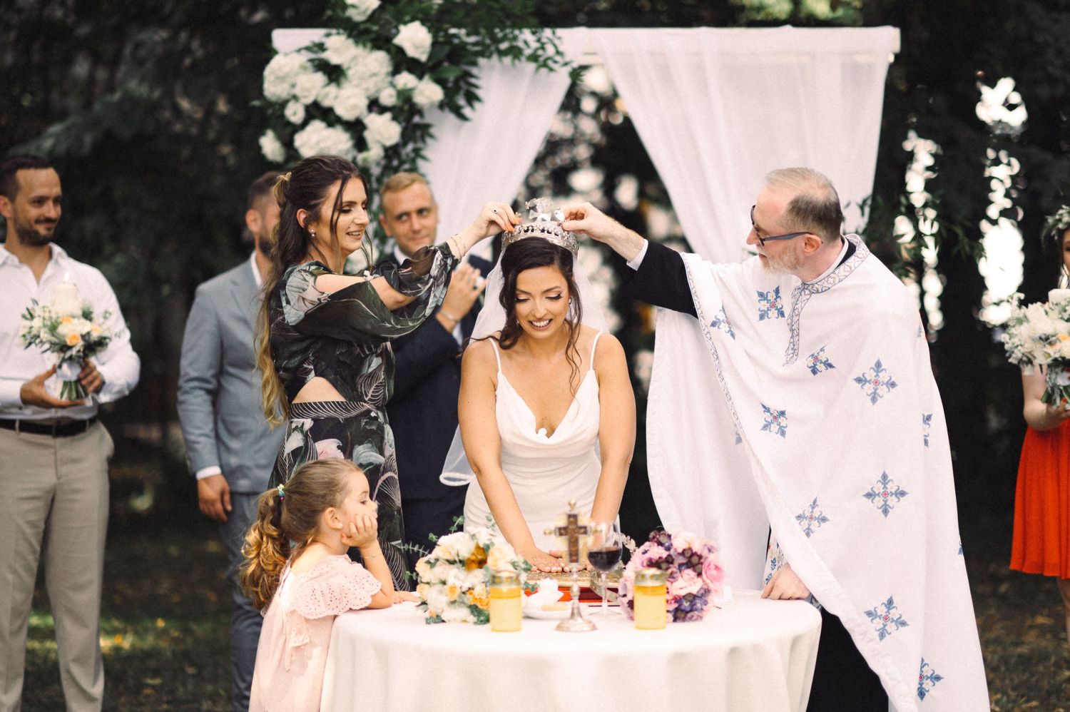 A joyous celebration around a decorated table during an outdoor wedding ceremony.