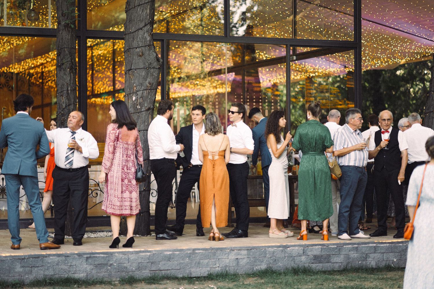 Wedding guests gathering on a covered patio during sunset celebrations.