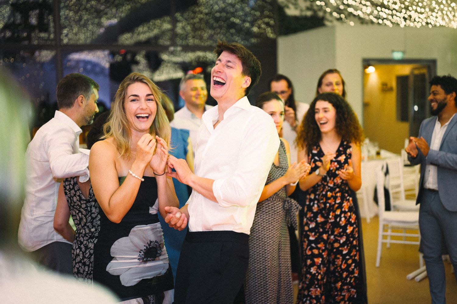 Joyful guests laughing and celebrating at an indoor party venue.