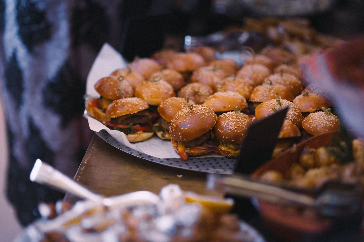 A platter of mini sliders or hamburgers served at a catered event.