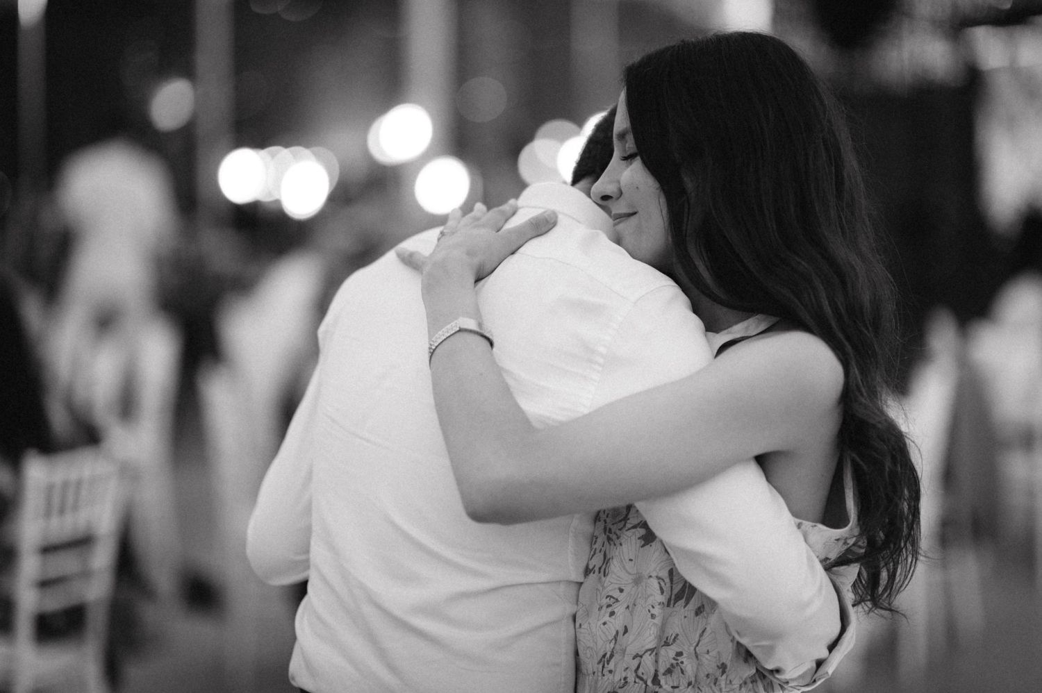 A black and white photo captures an intimate slow dance at a formal event.