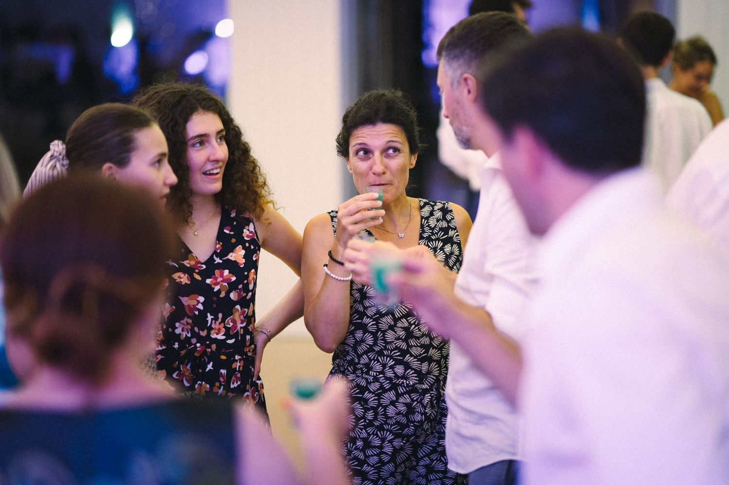 Party guests engage in animated conversation during a social gathering.