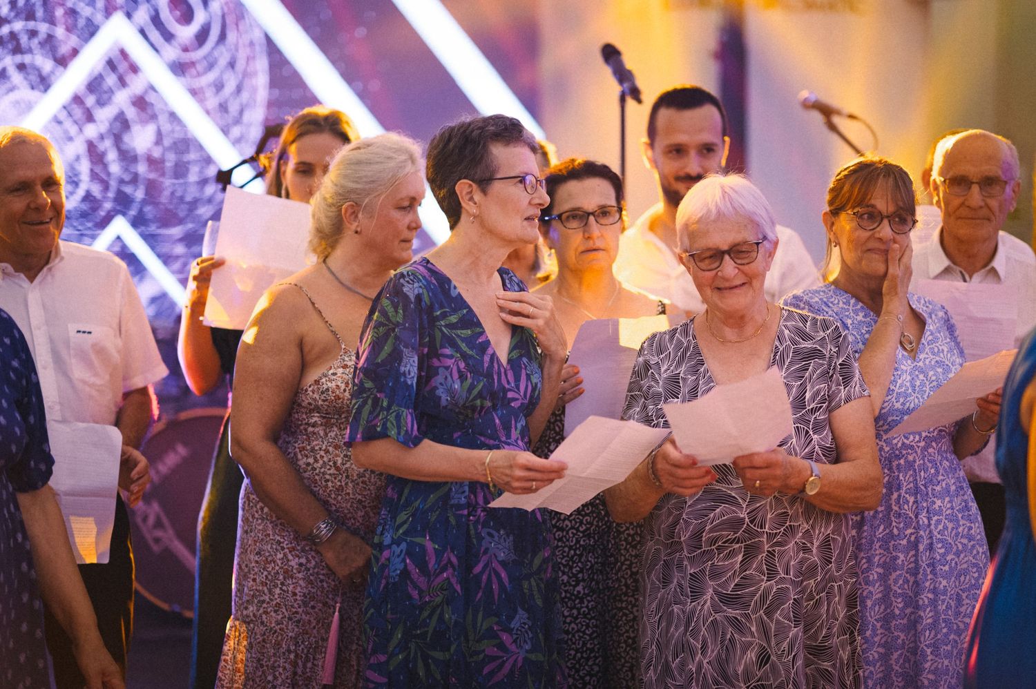 A group of guests reading together during a formal event with ambient lighting.