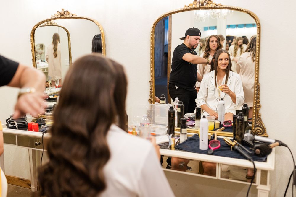 Preparations underway in an elegant bridal suite with ornate gold mirrors.