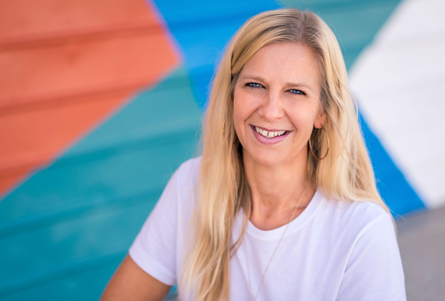Portrait against colorful geometric wall background wearing white t-shirt.
