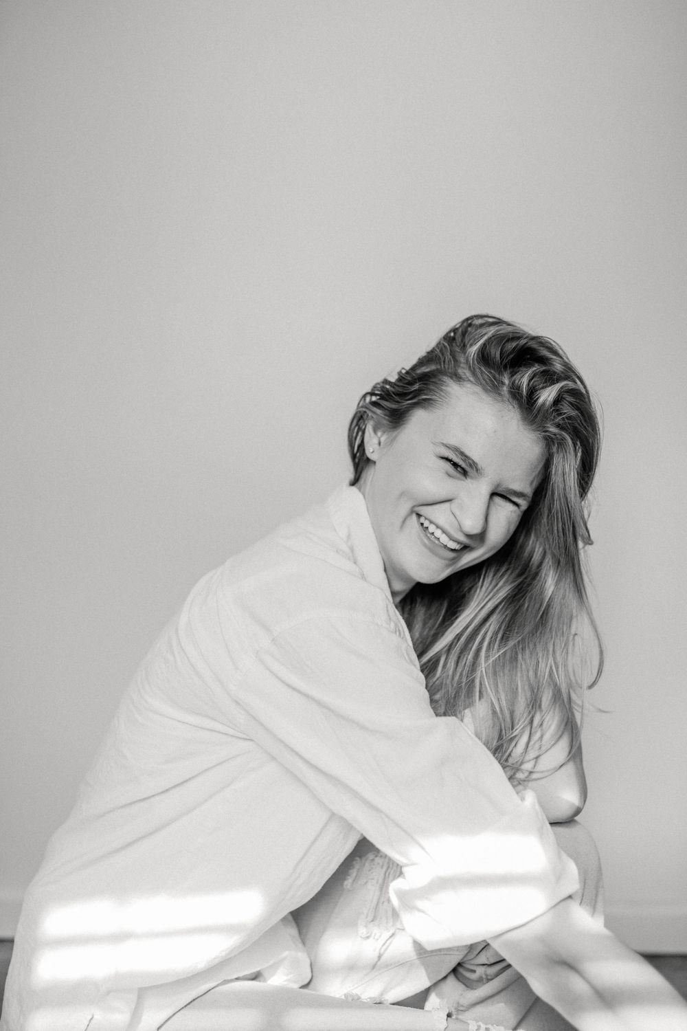 Black and white portrait of a joyful candid moment wrapped in cozy fabric.