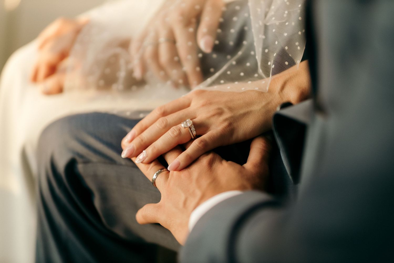 Close up of couple's hands with engagement ring during romantic moment.
