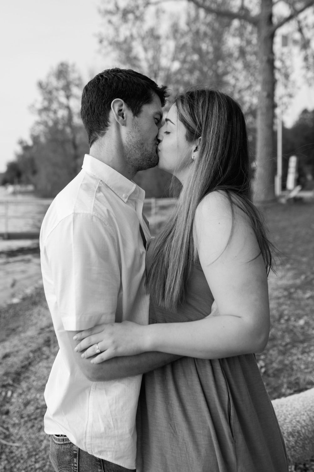 A romantic couple shares tender kisses in a series of black and white photos outdoors.