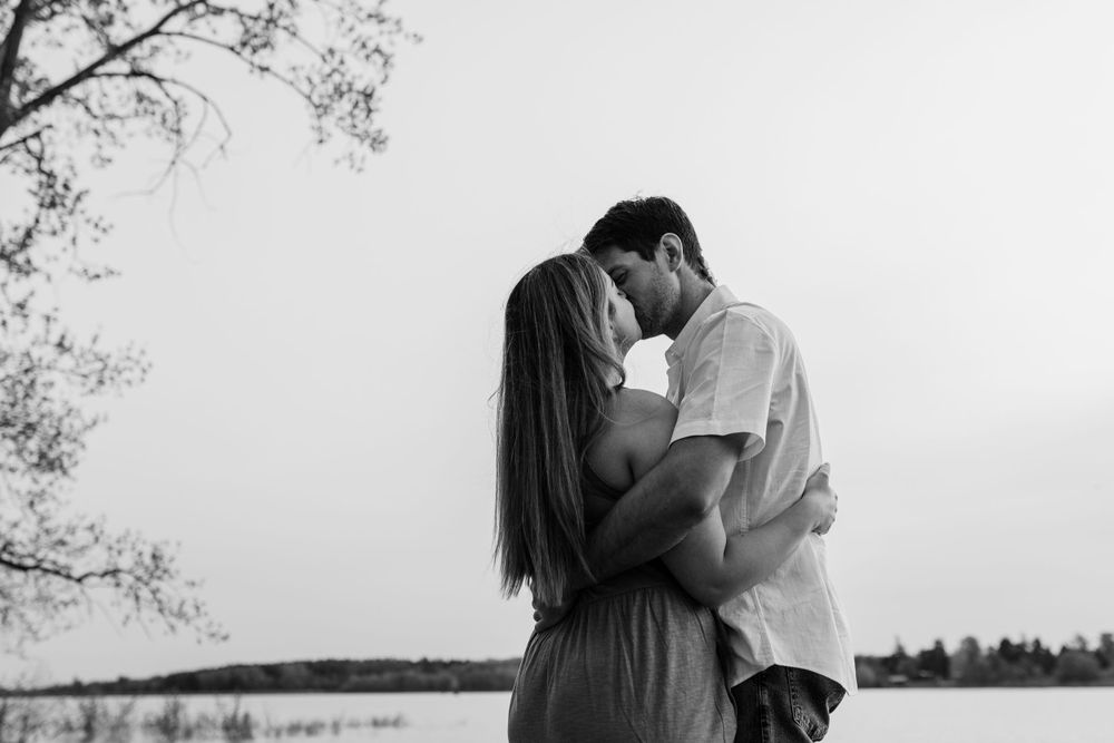 Black and white photos capture intimate moments between a couple by the water.