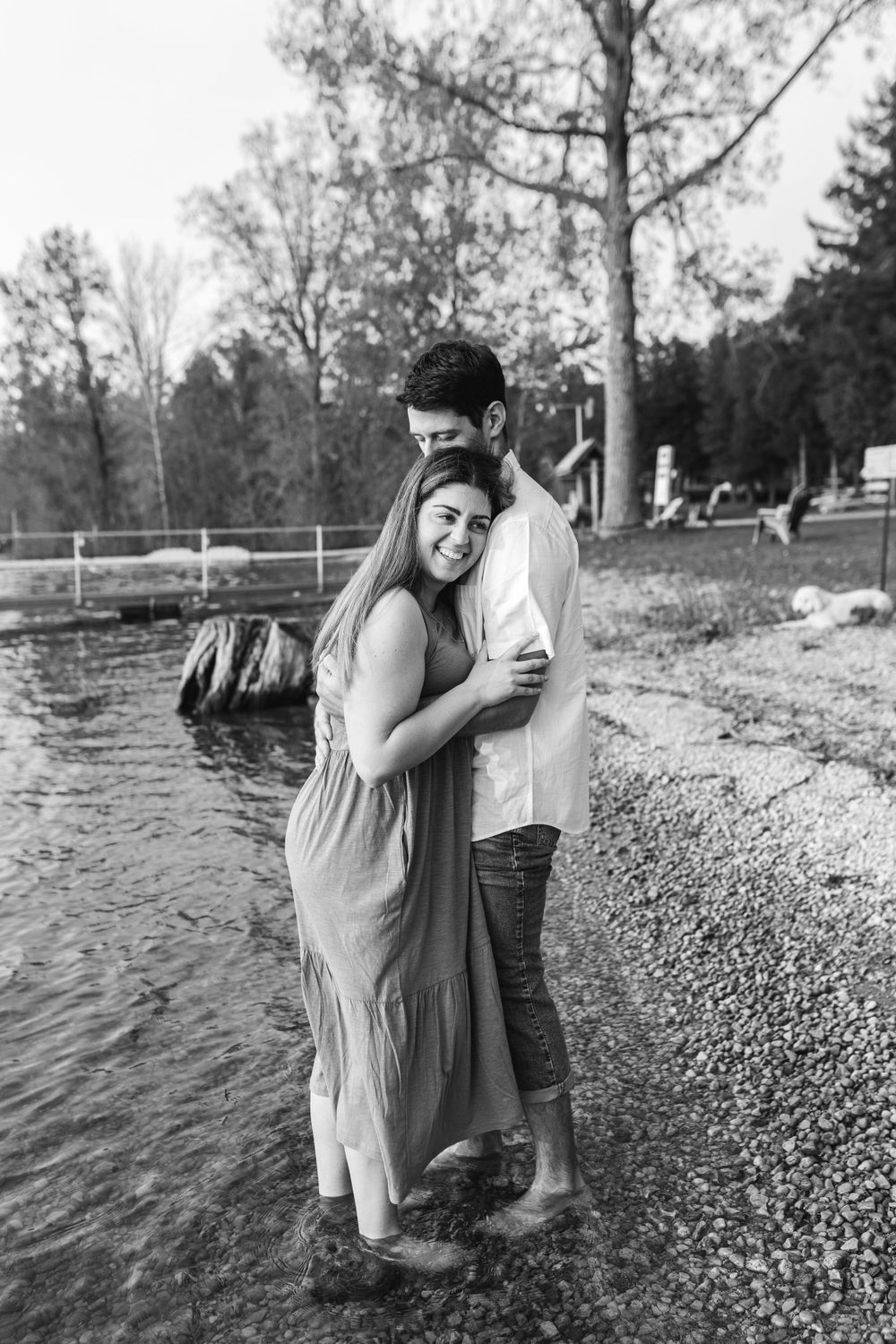 A couple shares loving moments during their engagement photoshoot on a rocky beach.