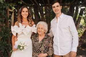 Family members gather for a casual photoshoot wearing coordinated white shirts and neutral colors.
