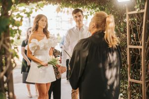 Small intimate wedding ceremony under a leafy pergola.