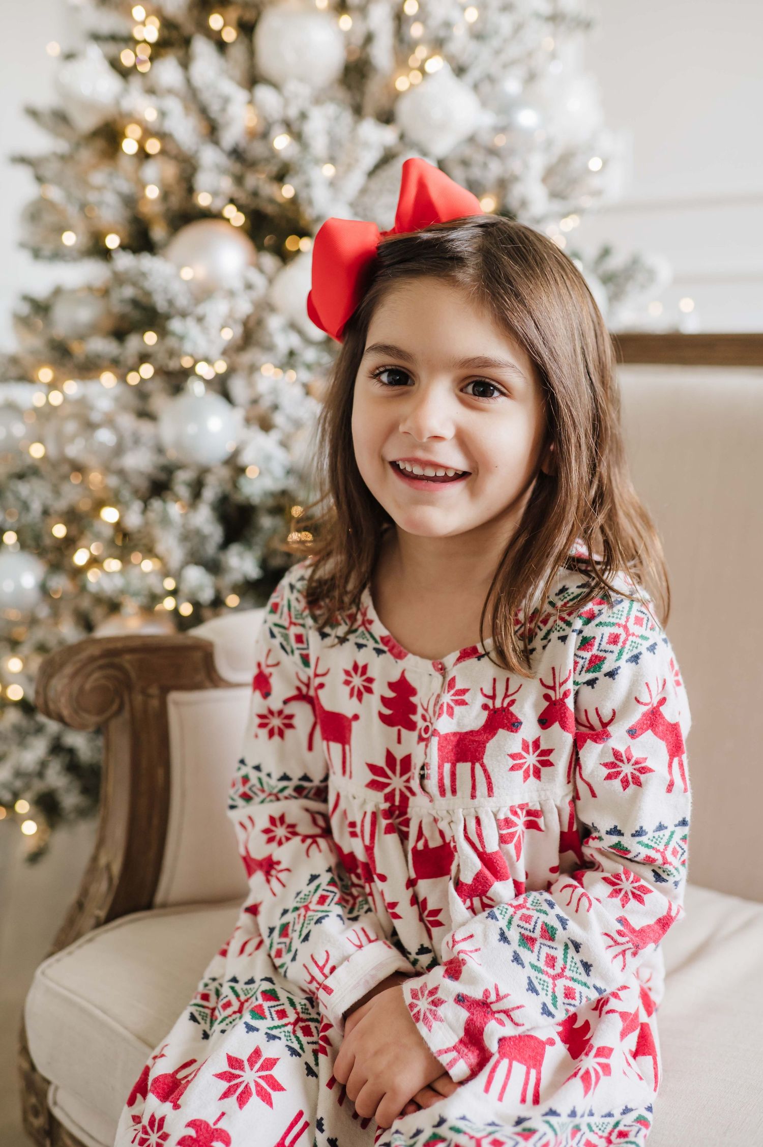 christmas mini in a studio with a  red and white hannah anderson christmas pjs with a red bow and a christmas tree
