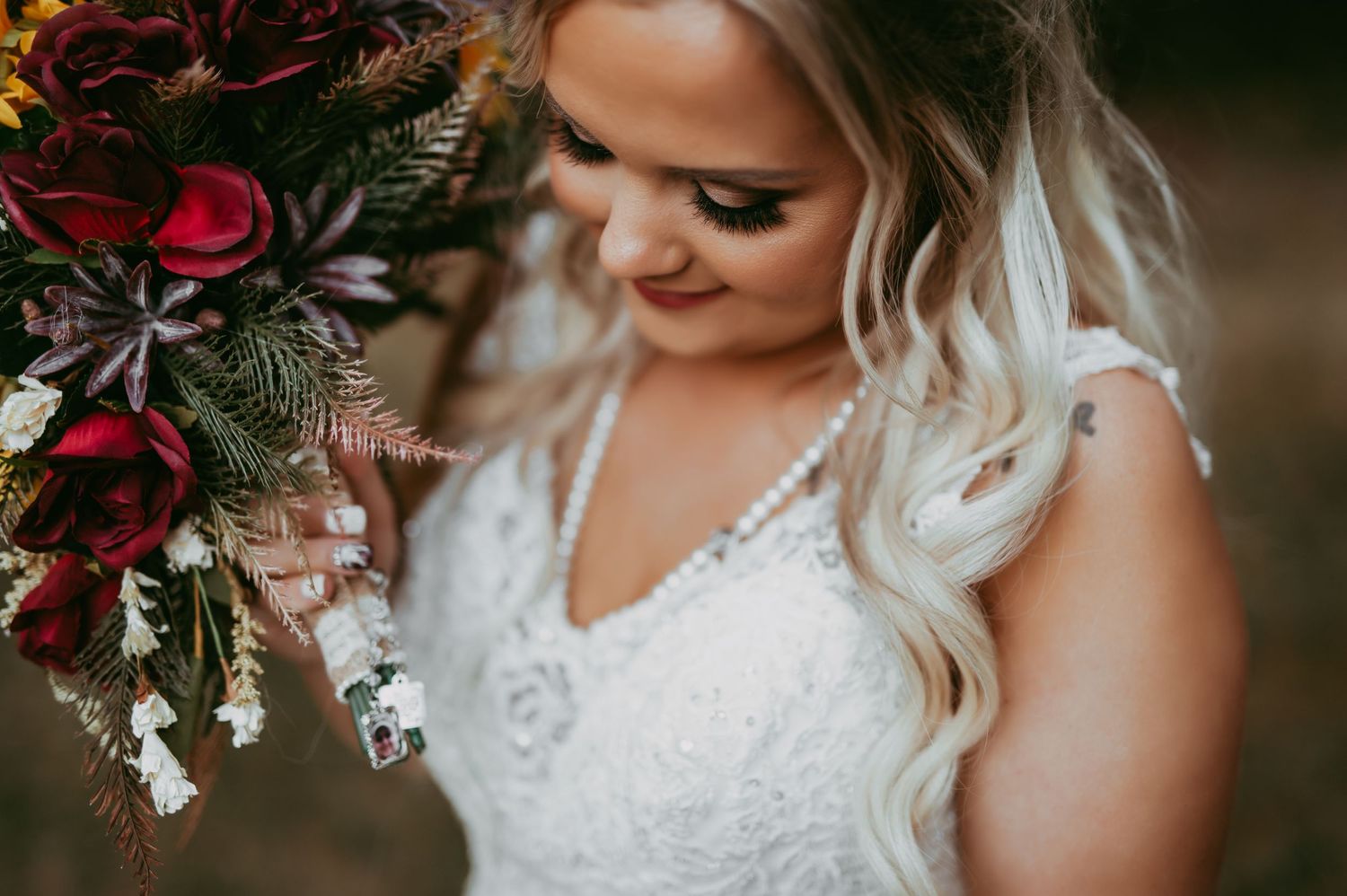 Kansas city wedding photographer. Bride honoring father during wedding. Bouquet charm. Father of the bride.