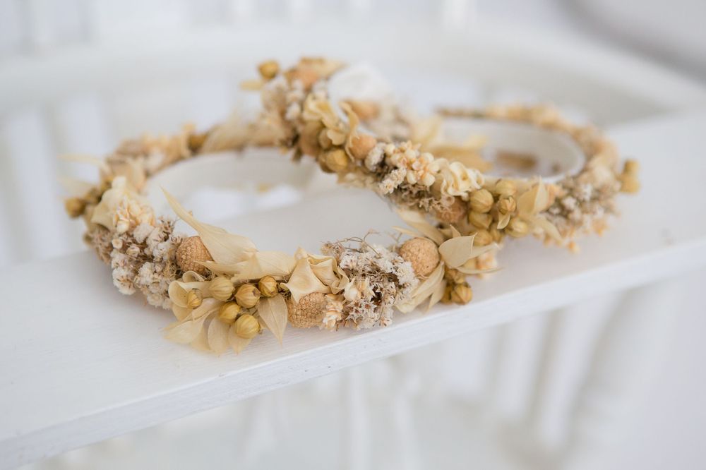 Delicate floral crown made with dried flowers and petals in neutral beige tones.