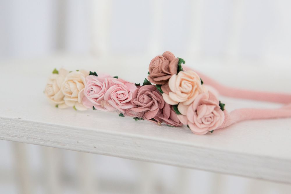 Pink and peach rose floral crown displayed on white surface.