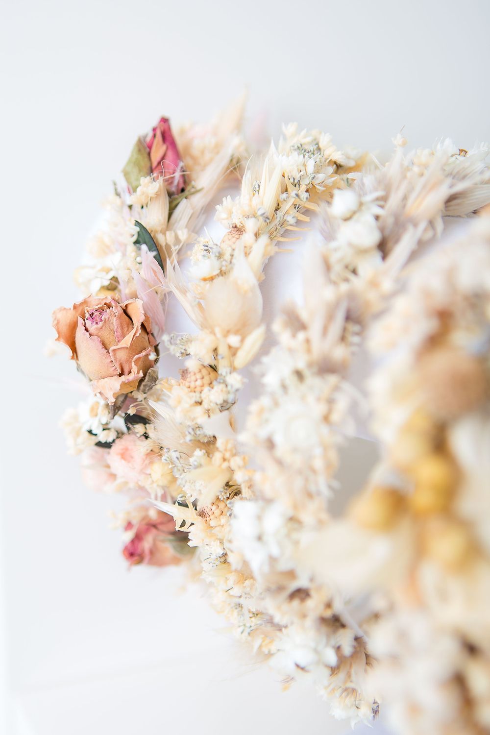 Delicate dried flower arrangement featuring pale pink roses and white blooms.