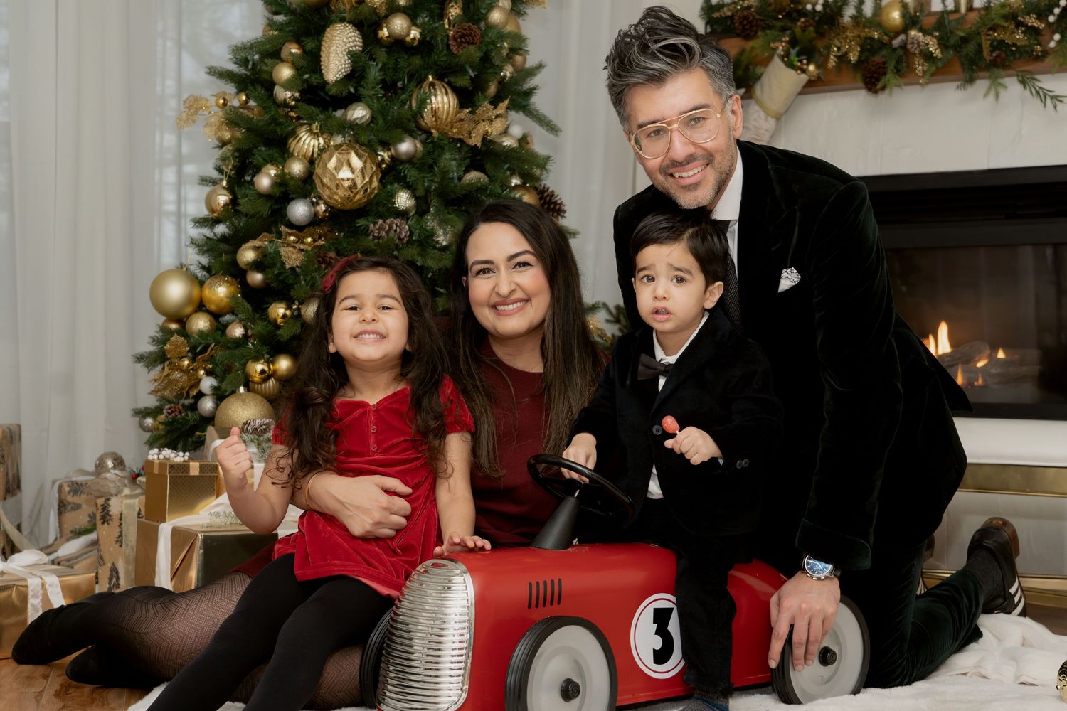 Holiday family portrait with decorated Christmas tree in background.