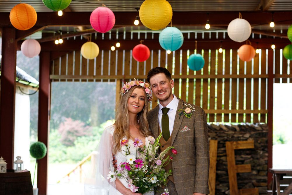Wedding scene with bright paper lanterns and rustic wooden backdrop.