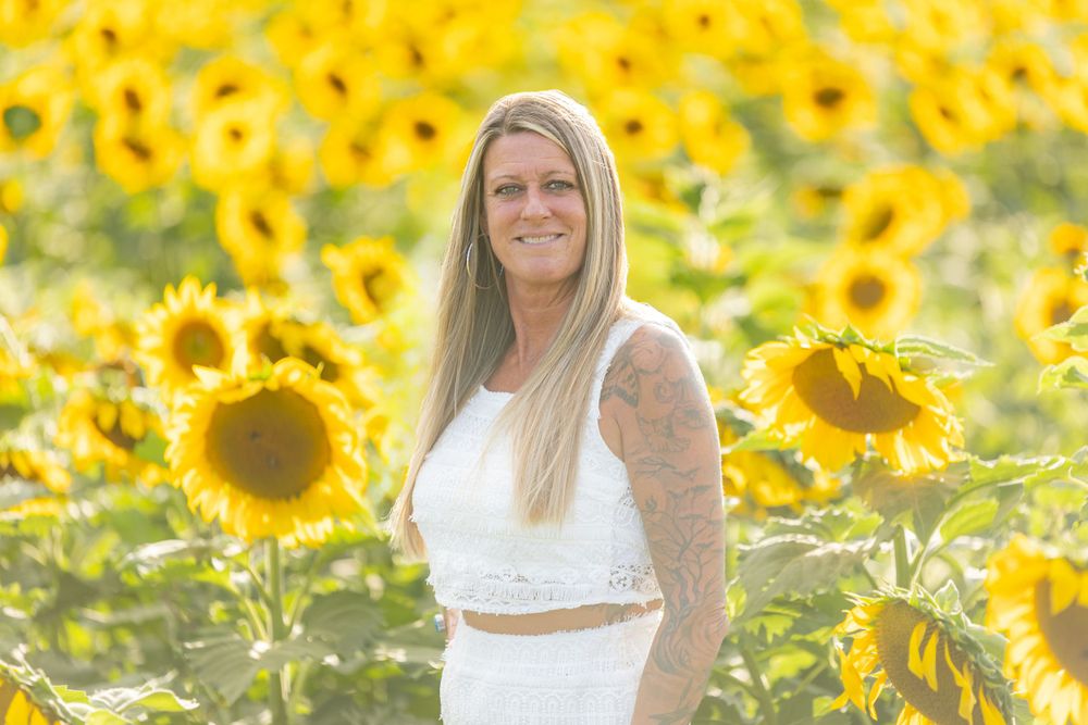 woman stylist wearing white and denim in sunflower field in clayton new jersey monroeville at sunset