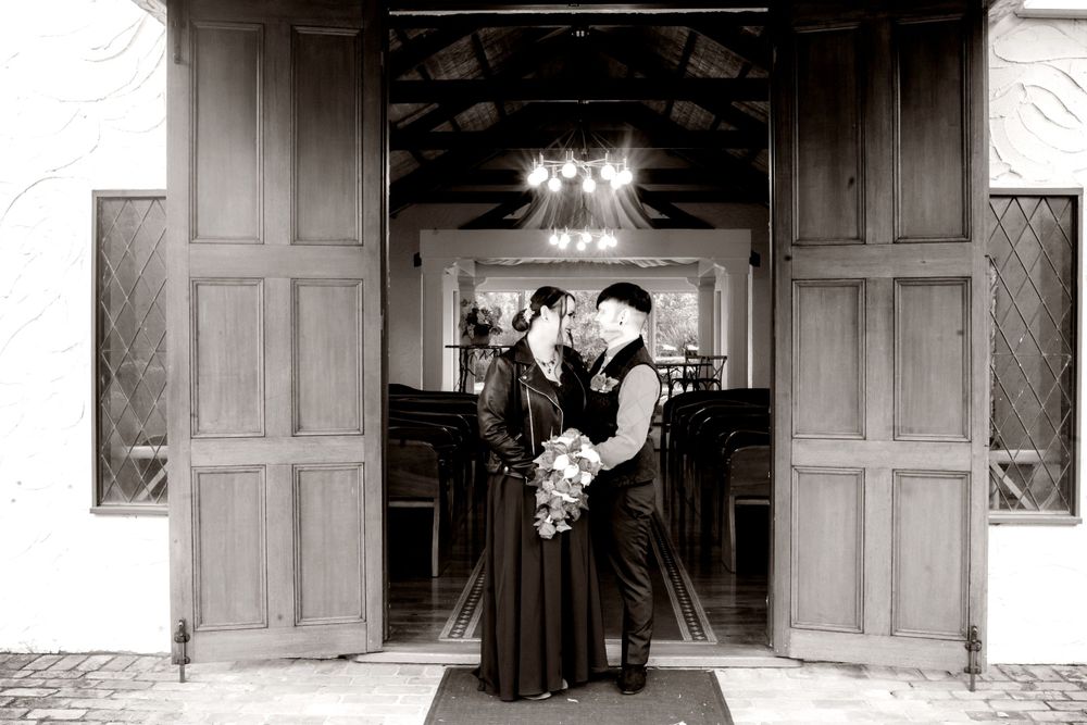 Bride in black dress and groom in black Architectural photo showing doorway entrances and building details in classic black and white style.