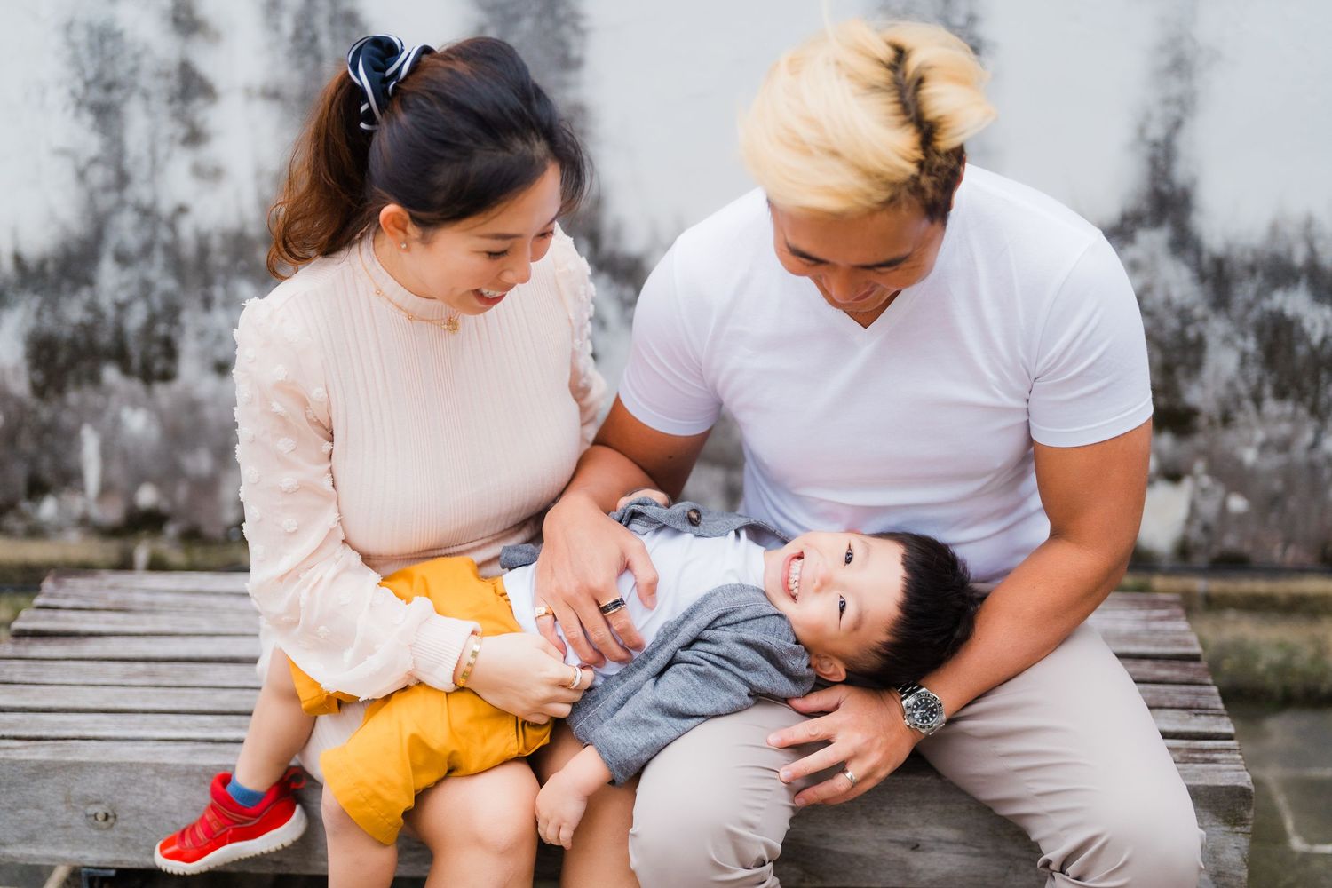 A family relaxing together on a wooden deck on a cloudy day.