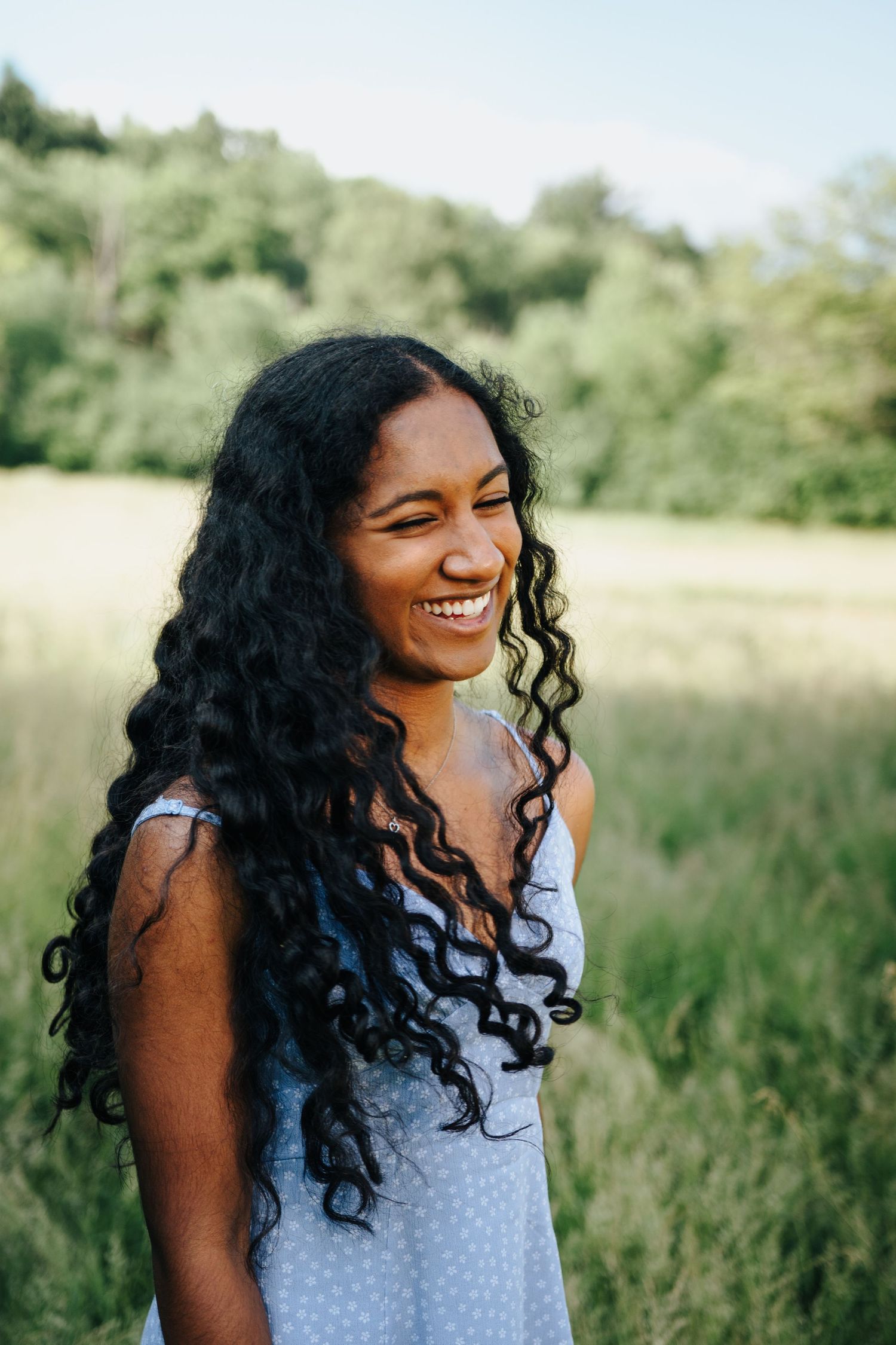 Expressive portraits of a person laughing joyfully in a summer field.