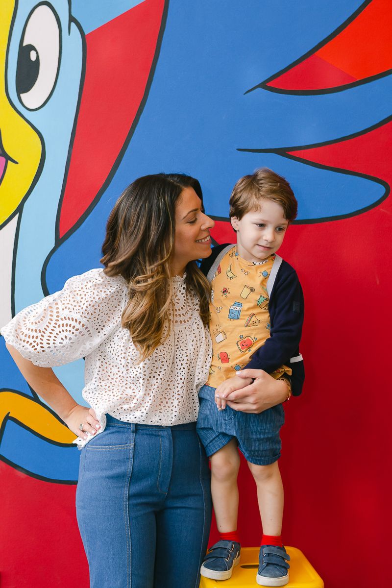 a jewish mother with her toddler son during a candid moment against a Kellogg's mural in primary colors in Manhattan