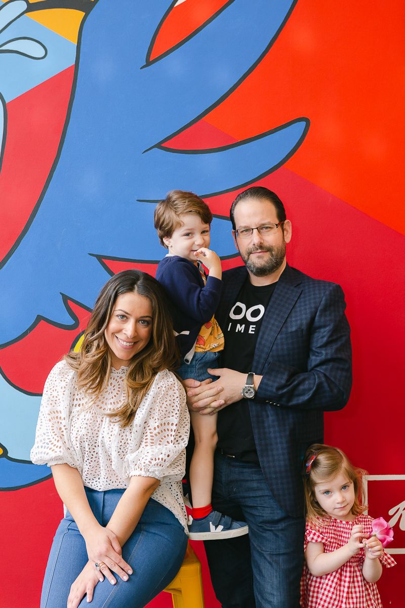 a jewish family of four standing in front of a colorful mural with blue and red photographed by Paula Ortiz NY Family