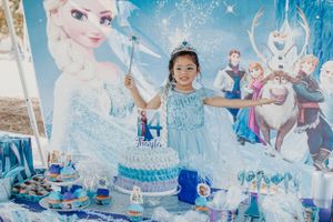 Winter wonderland party setup featuring blue and white decorations with snowy accents.