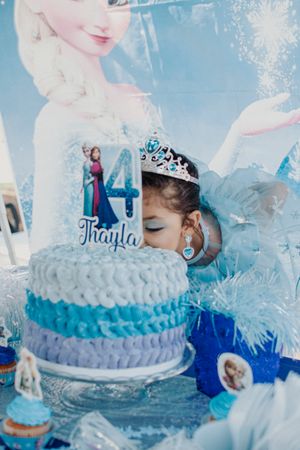 Elegantly decorated winter-themed birthday cake with blue ombre frosting and snowflake accents.