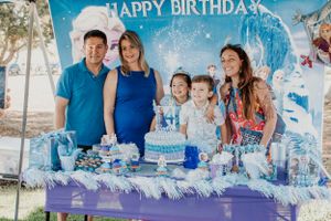Family celebration with winter-themed decorations and blue accents outdoors.