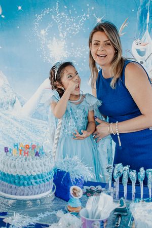 A festive Frozen-themed birthday party setup with a blue ombre cake and sparkling decorations.