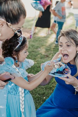 People enjoying cake and laughter at an outdoor birthday celebration.