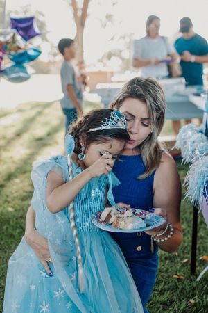 An emotional moment shared during a birthday party with cake outdoors.