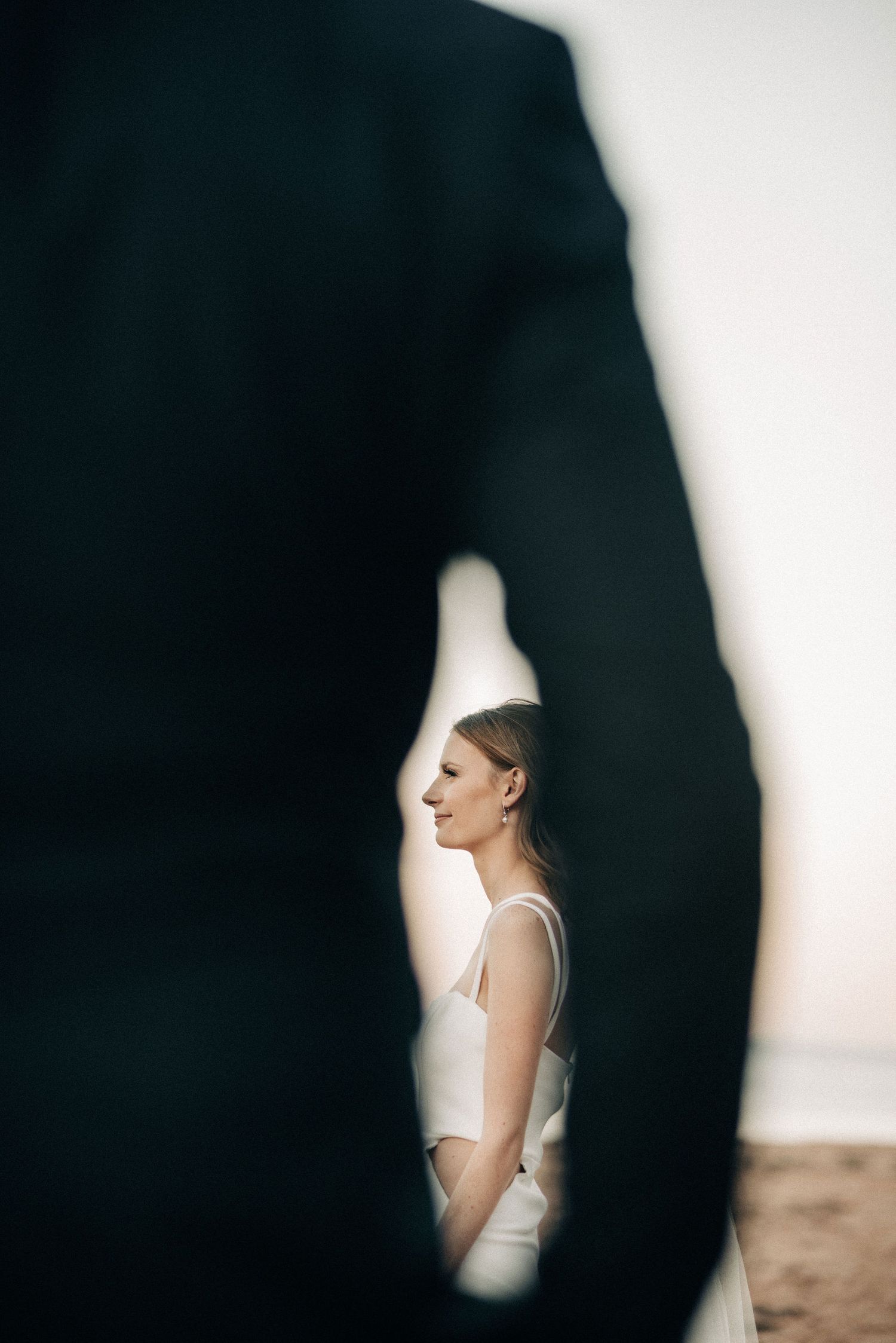 Creative wedding portrait framed through silhouette against white background.