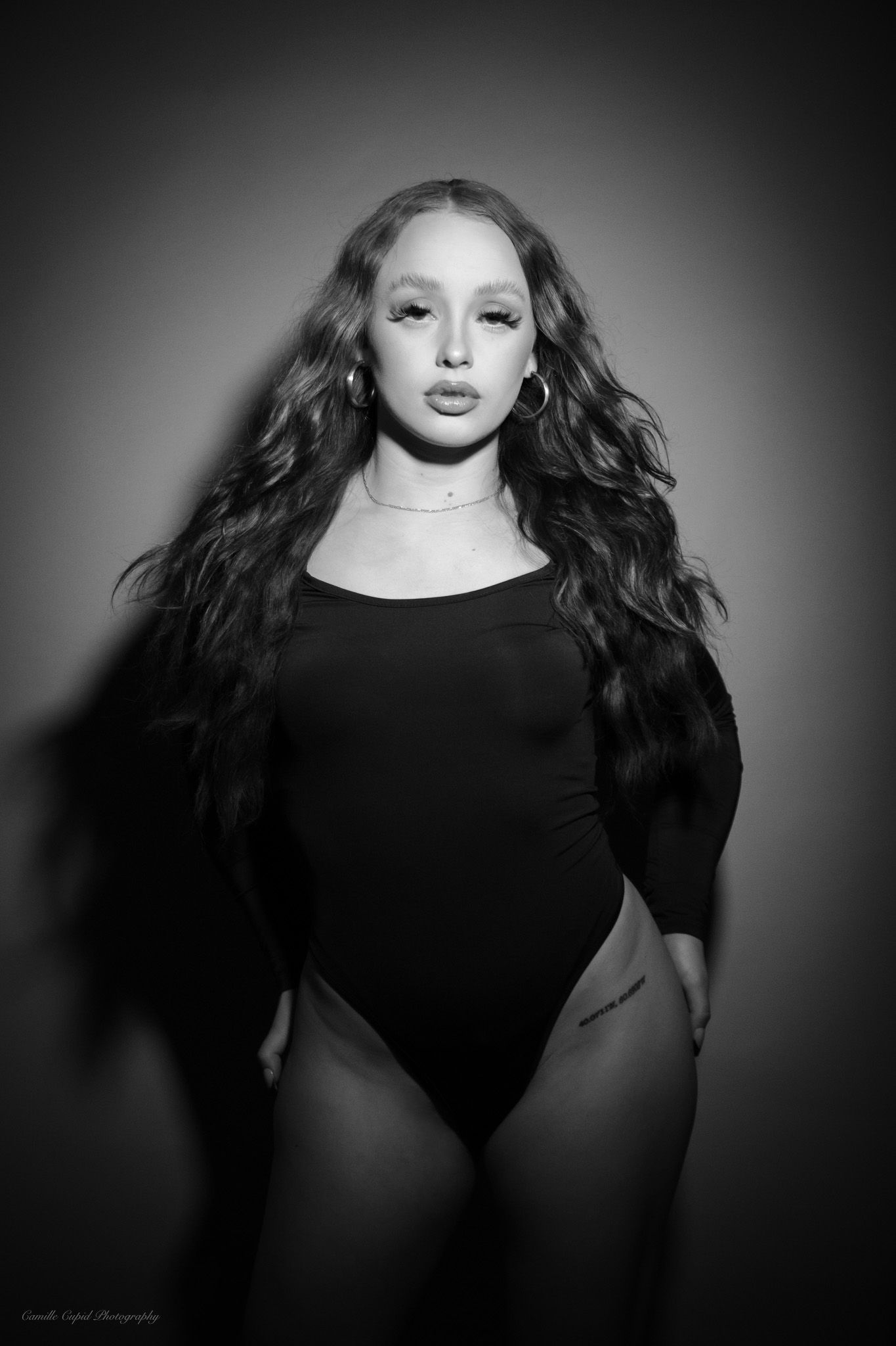 Artistic black and white image showcasing a stylish Fashion Nova bodysuit on a feminine model