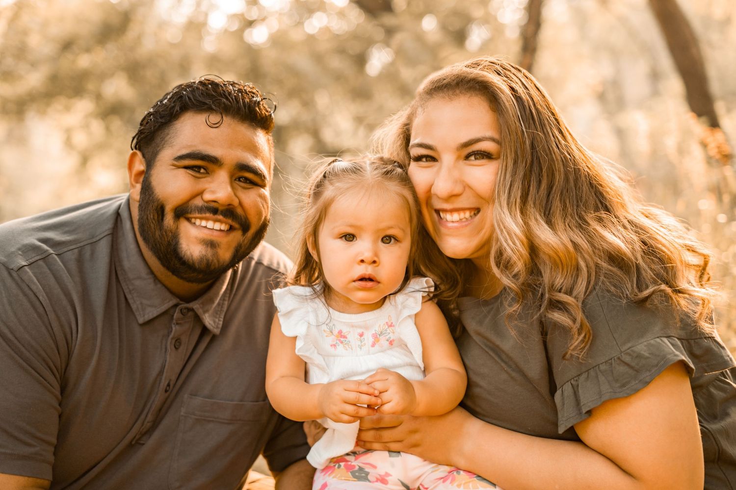 Warm-toned family portrait captured outdoors during golden hour.