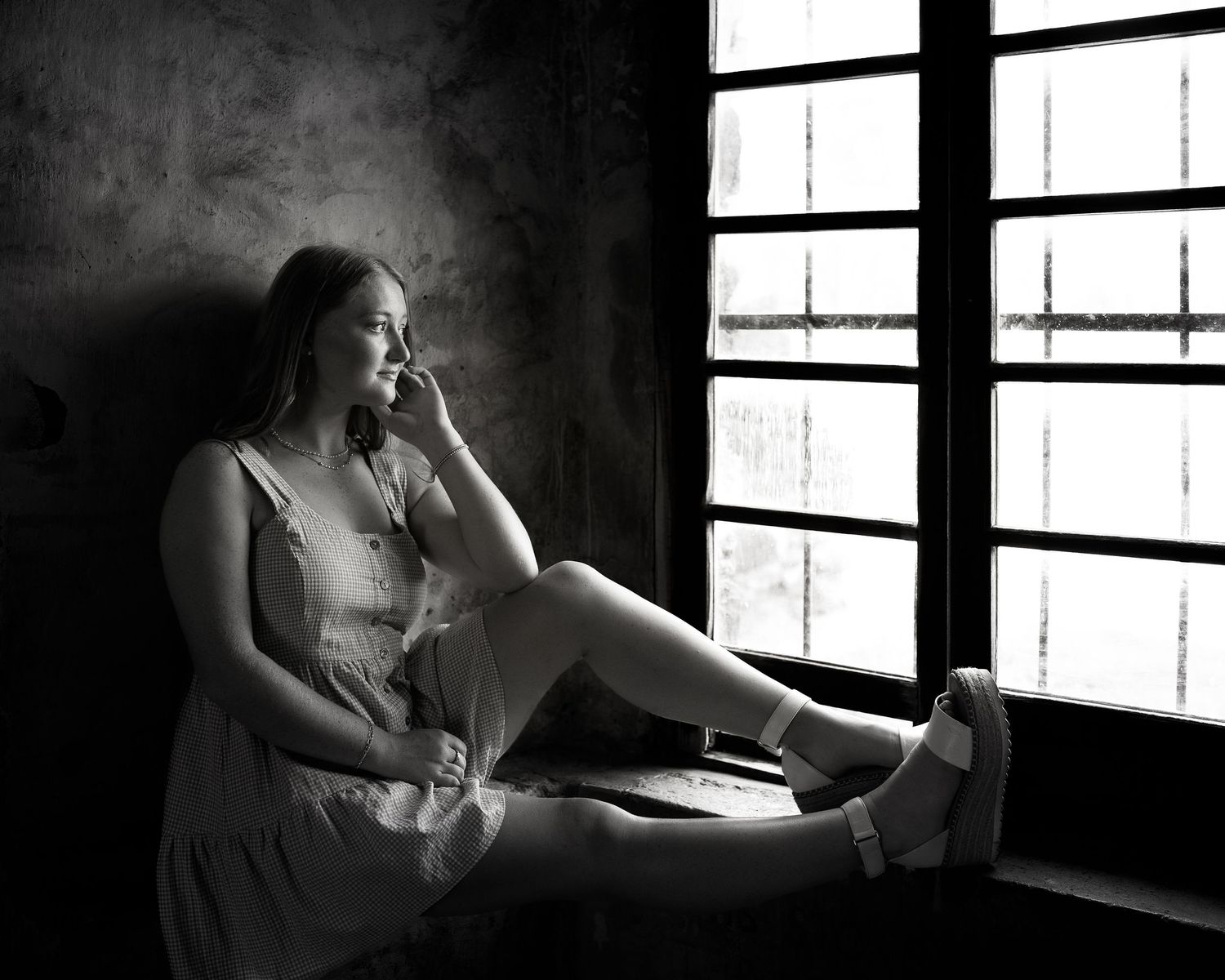 black and white portrait of high school senior girl looking out a window in San Antonio Texas
